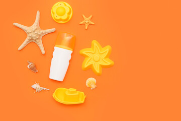 Beautiful composition with sunscreen and beach accessories for children on orange background