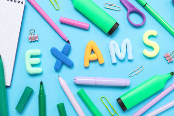 Composition with word EXAMS and colorful stationery on color background