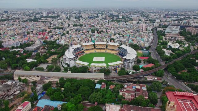 Chepauk railway station with cricket stadium and crowded residential buildings at wallahjah road, chepauk, triplicane, chennai, tamil nadu, india. day time, push in, tilt up, drone shot, 4k.