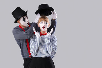 Couple of pantomimists on grey background