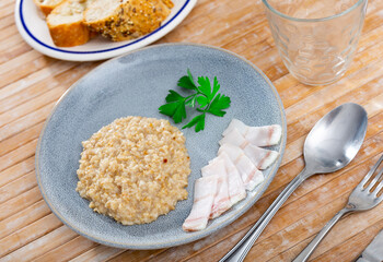 Appetizing lard with hot oatmeal and parsley. Hearty healthy dish