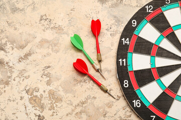 Dartboard with darts on beige grunge background