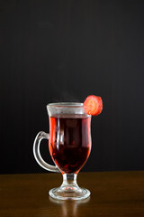 Hot red drink in a glass with dark background