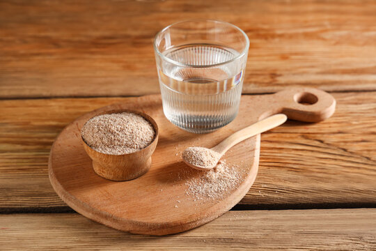 Glass of water with psyllium husk on wooden background