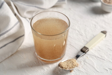 Glass of water with psyllium husk on white grunge background