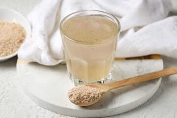 Glass of water with psyllium husk on white grunge background