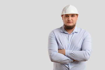 Young male engineer on light background