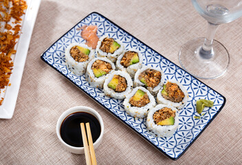 Rolls with salmon fish avocado and fried onions with bowl of soy sauce