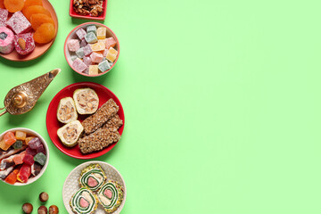Fototapeta premium Composition with different Eastern dishes and Aladdin lamp on green background. Ramadan celebration