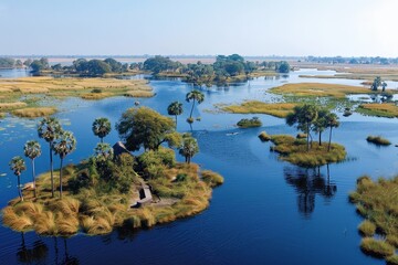 Obraz premium A serene landscape of islands surrounded by water, featuring lush greenery, palm trees, and a clear blue sky.