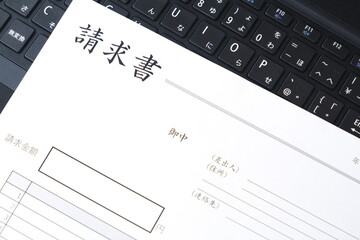 取引先に宛てた請求書を作成しているビジネスシーンのイメージ
