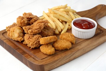 Naklejka premium Crispy Fried Chicken, Golden French Fries, and Tangy Ketchup: A Delicious Fast Food Feast on a Wooden Platter