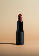 Minimal Studio Shot of Burgundy Lipstick on Beige Background