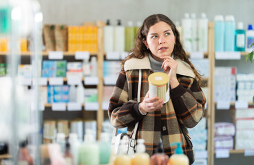Girl in winter clothes buys food for small children in supermarket