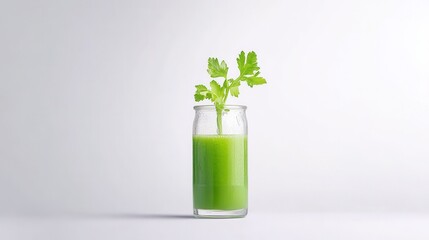 Fresh green juice in clear glass jar with vibrant green herb stems