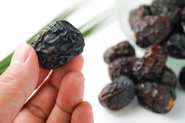 Dates fruit ajwa or kurma ajwa, in hand isolated on white background