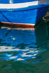Colourfull reflections of the hull and masts of yachts on the water