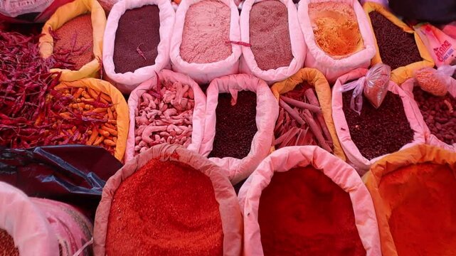 A variety of Indian spices, including turmeric powder, coriander powder, and whole spices (khade masale), displayed on a rustic background. Essential ingredients for Indian cooking, seasoning.
