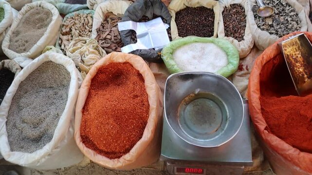 A variety of Indian spices, including turmeric powder, coriander powder, and whole spices (khade masale), displayed on a rustic background. Essential ingredients for Indian cooking, seasoning, and Ayu