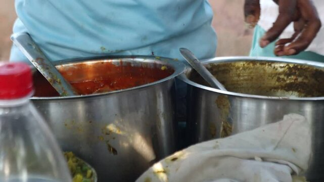 stuffing golgappe with mashed potato, mixing sweet tamarind chutney (sonth), showcasing Indian street food preparation.