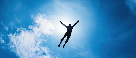 A silhouette of a person leaps against a bright blue sky, embodying freedom and exhilaration in a moment of flight.