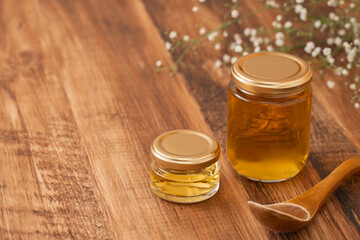 木目の背景に蜂蜜瓶とコムハニー