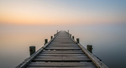 Obraz premium Serene Wooden Dock Extending into Misty Lake at Sunrise