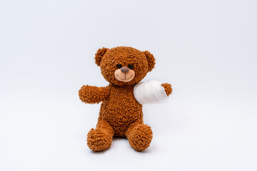 A bear toy with a bandaged paw, a broken limb, a trauma center and pediatrics, on an isolated background,