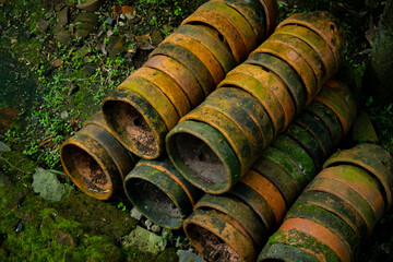 Pile of old terracotta plant pots covered with moss, with shallow depth of field