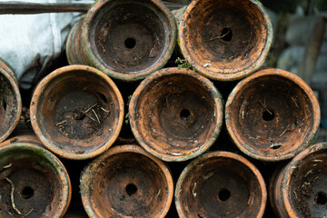 Pile of old terracotta plant pots covered with moss, with shallow depth of field