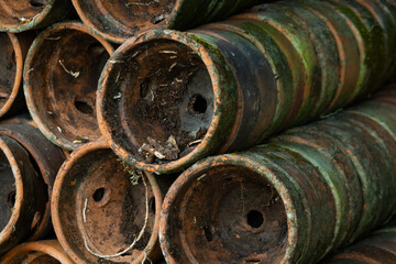 Pile of old terracotta plant pots covered with moss, with shallow depth of field