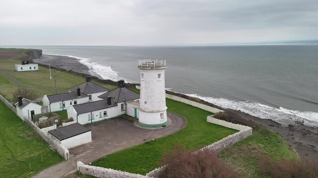 Drone view of Nash Point Lighthouse, UK, capturing its  structure perched on the coastline