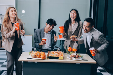 Asian office colleagues and friends enjoy a daytime BBQ with pizza and beer, celebrating Halloween and cheering for their favorite soccer team, creating a lively atmosphere filled with joy.