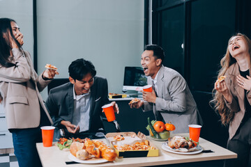 Asian office colleagues and friends enjoy a daytime BBQ with pizza and beer, celebrating Halloween and cheering for their favorite soccer team, creating a lively atmosphere filled with joy.