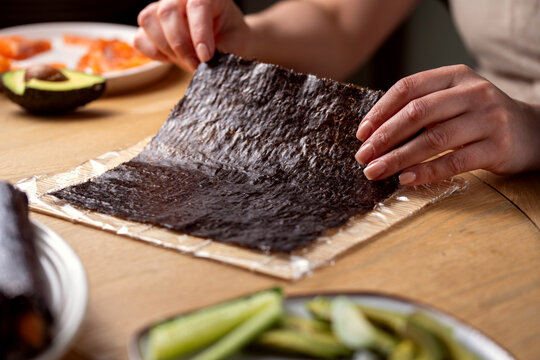 Process of making homemade sushy at home, hands with nori