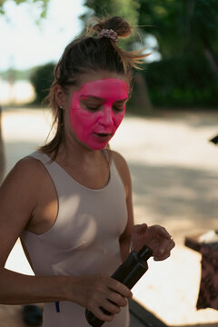 Surfer gets pink zinc sunscreen applied to her face