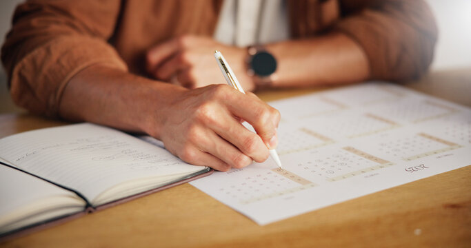 Person, planning and hands with date on calendar for agenda, deadline update and time management. Closeup, notebook and schedule for tasks reminder, appointment notes or productivity planner at table
