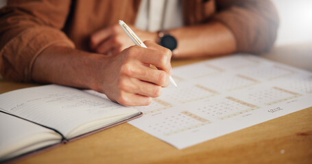 Person, planning and hands with writing on calendar for agenda, deadline update and time management. Closeup, notebook and schedule for tasks reminder, appointment date and notes planner at table