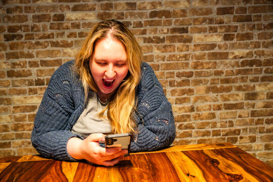Expressions of surprise and boredom by a mother engaging with her phone in a cozy setting
