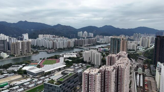 Aerial footage of Sha Tin town, with residential and commercial building developments on both banks of the Shing Mun River.