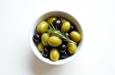 Fototapeta premium Overhead shot of bowl with mix green black olives with rosemary sprig on white. Tasty appetizer for a cocktail. Italian and Spanish cuisine for restaurants and cafe menus. Healthy mediterranean food.