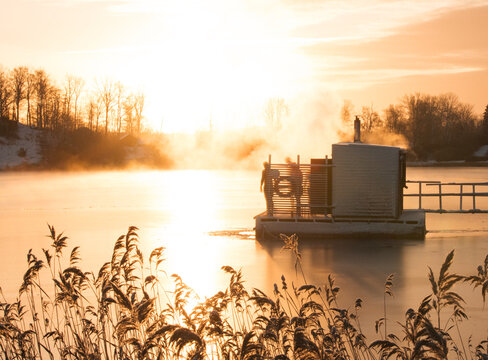 people enjoying a floating sauna at sunset in the Swedish archipelago