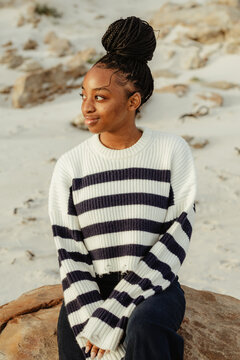 Beautiful young black women with smile on the beach in winter clothes