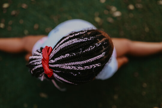 Mixed race girl with pink and brown hair braids doing the splits