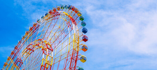 The majestic Ferris wheel stands against the clear blue sky. Panoramic view.