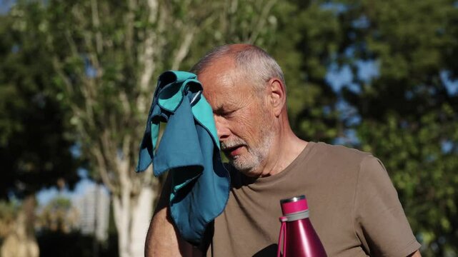 Senior man wiping sweat from forehead in slow motion