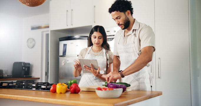 Couple, food and cooking with tablet in kitchen for online recipe, meal instructions or salad tutorial. People, digital cookbook or cutting ingredients for healthy dinner or internet guidance in home