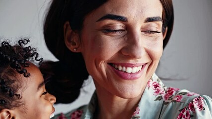 Close up happy African mom and daughter or son cuddling seated on sofa. Loving parent hug 6s daughter express love, showing caress. Little girl feels grateful embrace new mum. Adoption, Mothers day co