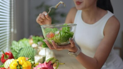Young woman enjoying nutritious salad in kitchen, savoring fresh vegetables and embodying healthy eating lifestyle with vibrant wellness and pleasure
