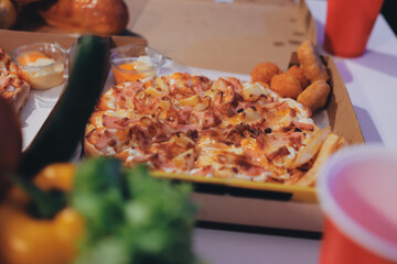 Happy young friends group having lunch at home. Asia family party eating pizza food and laughing enjoying meal while sitting at dining table together at house. Celebration holiday and togetherness.
